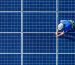 A worker on a rooftop solar panel array